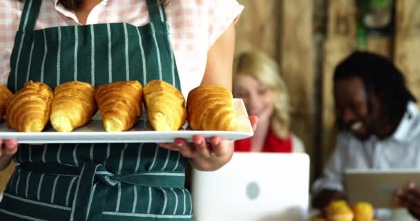 Female waitress holding tray of croissant — Stock Video