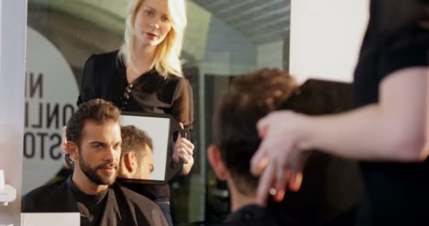 Cabeleireiro mostrando o homem seu corte de cabelo — Vídeo de Stock
