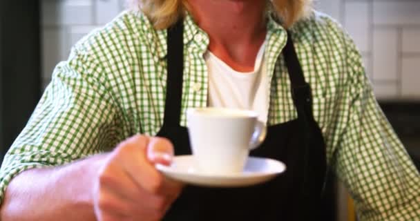 Мужчина официант держит чашку кофе — стоковое видео