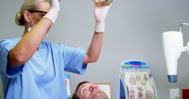 Assistante dentiste féminine ajustant la lumière dentaire — Video