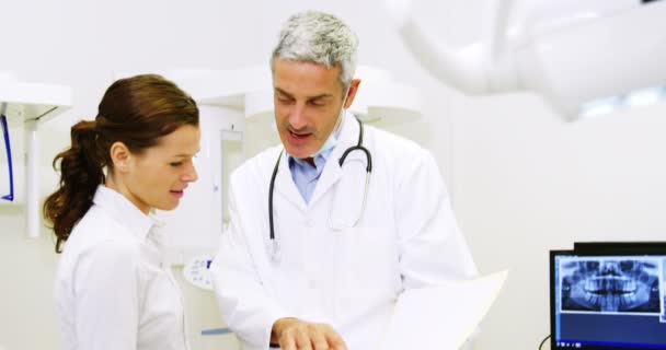 Dentista discutindo relatório com paciente — Vídeo de Stock