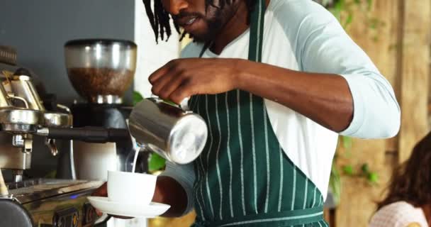 Кафе официант наливает молоко в чашку — стоковое видео