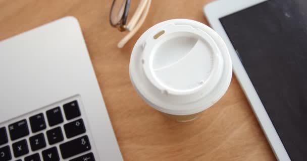 ノート パソコンとタブレットの机の上のカップ — ストック動画