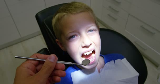 Стоматолог осматривает молодого пациента — стоковое видео