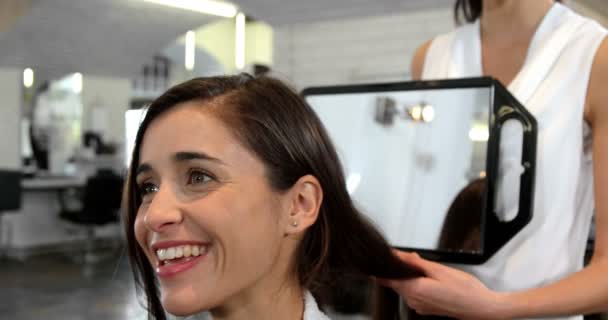 Estilista mostrando mujer su corte de pelo — Vídeo de stock