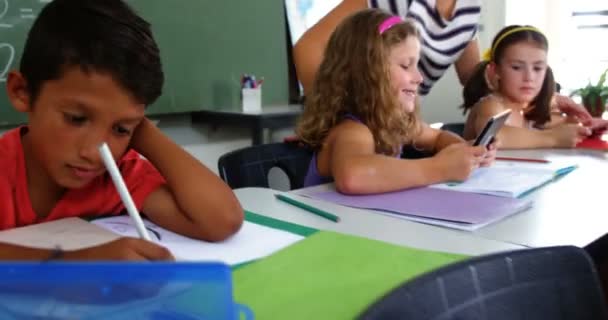 Učitel pomáhá schoolkids s domácími úkoly — Stock video