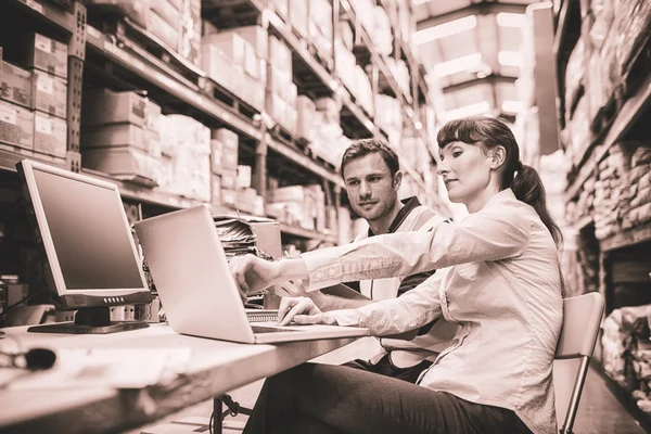 Lagerarbeiter und Manager schauen auf Laptop — Stockfoto