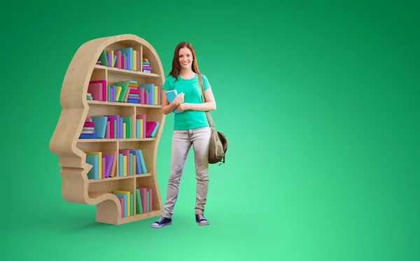 Estudante sorrindo para a câmera na biblioteca — Fotografia de Stock