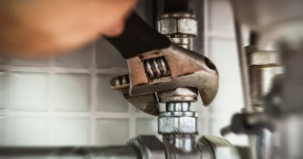 Mão de reparação de tubos com chave inglesa — Fotografia de Stock