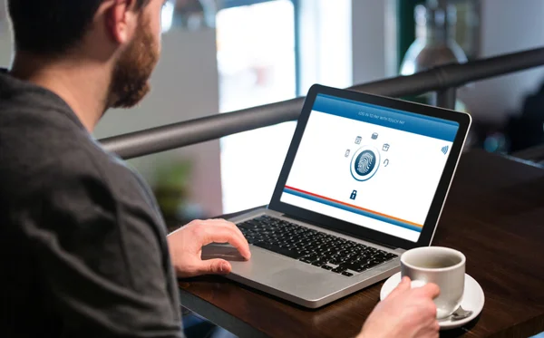 Mann hält Kaffeetasse in der Hand und benutzt Laptop — Stockfoto