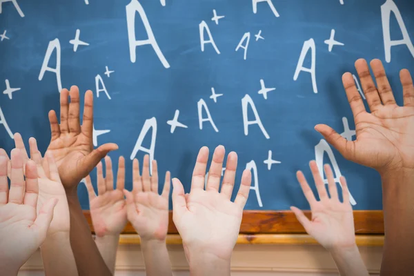 Handen verhogen in lucht tegen blackboard — Stockfoto