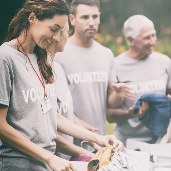 Счастливый волонтер смотрит в ящик для пожертвований — стоковое фото