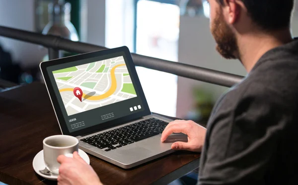 Homem segurando xícara de café e usando laptop — Fotografia de Stock