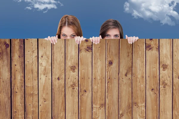Women hiding behind wooden planks — Stock Photo, Image