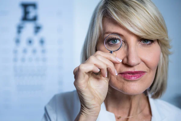 Optométriste féminine regardant à travers la loupe — Photo