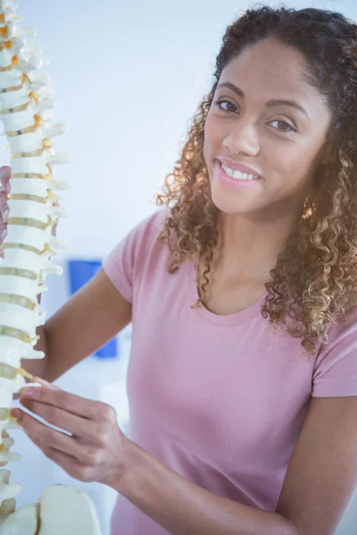 Retrato de mujer sosteniendo el modelo de columna vertebral — Foto de Stock