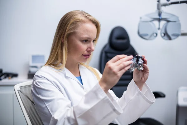 Vrouwelijke optometrist kijken door messbrille — Stockfoto