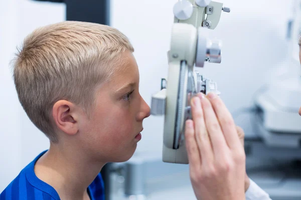 Mladý pacient pod oční test prostřednictvím phoropter probíhající — Stock fotografie