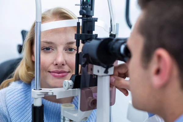 Оптометрист осматривает пациентку на щелевой лампе — стоковое фото