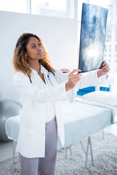 Physiotherapist holding spine x-ray of patient — Stock Photo, Image