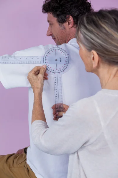 Fyzioterapeut, měření mužských pacientů zpět — Stock fotografie
