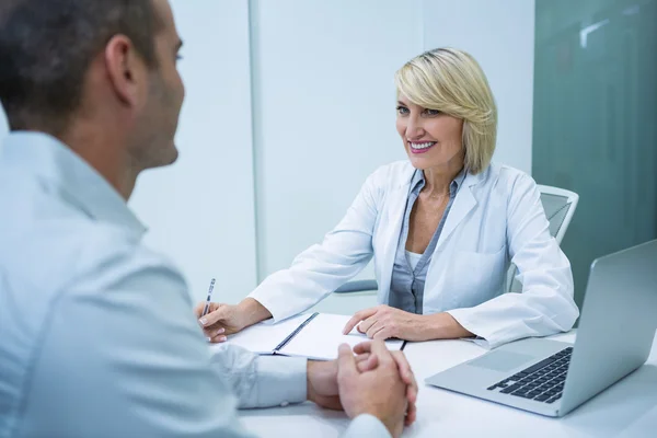 Vrouwelijke optometrist praten met mannelijke patiënt — Stockfoto