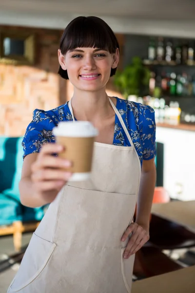 Χαμογελαστή σερβιτόρα προσφέροντας ένα φλιτζάνι του καφέ — Φωτογραφία Αρχείου
