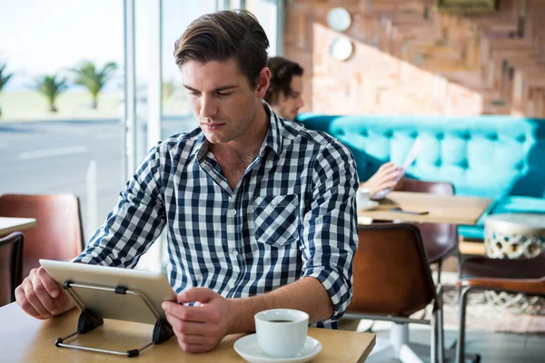 Hombre usando tableta digital en la cafetería — Foto de Stock