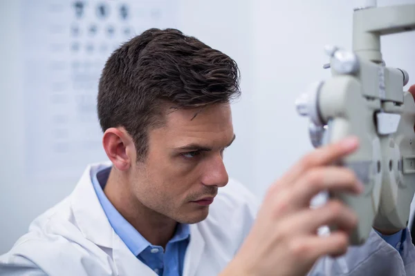 Attente optometrist kijken door phoropter — Stockfoto