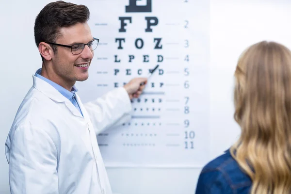 Optometrista que toma la prueba ocular del paciente femenino — Foto de Stock