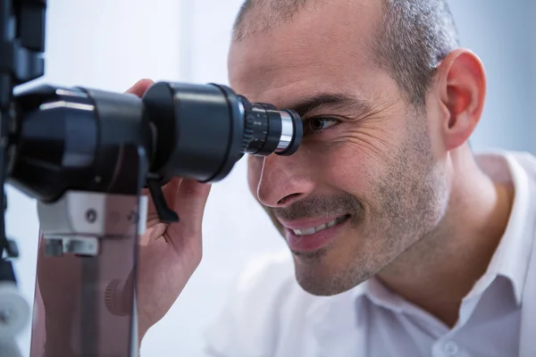 Optometrista che guarda attraverso il biomicroscopio — Foto Stock