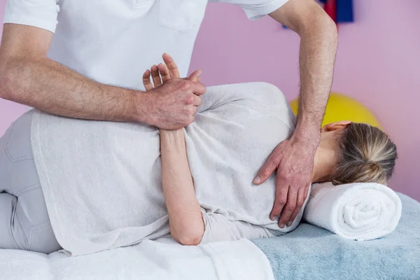 Physiotherapeutin massiert eine ältere Frau an der Schulter — Stockfoto