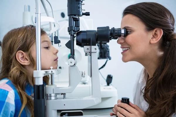 Optometrista femenina examinando paciente joven en lámpara de hendidura — Foto de Stock