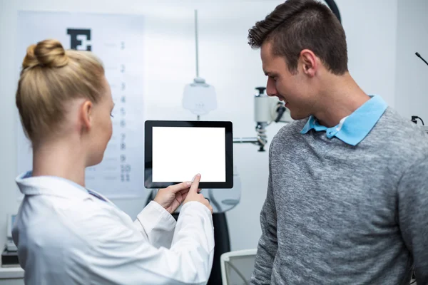 Optometrista do sexo feminino tendo discussão com paciente em guia digital — Fotografia de Stock