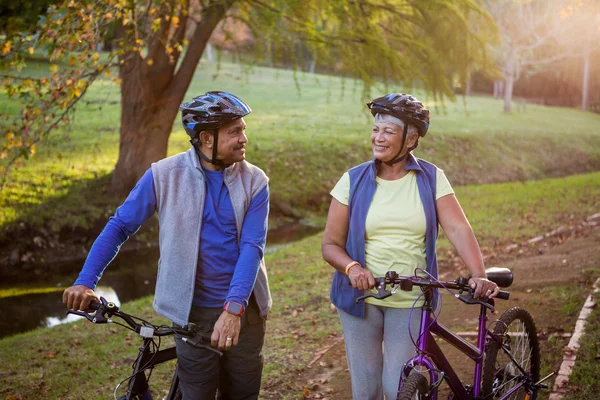 Pasangan dewasa berjalan dengan sepeda — Stok Foto