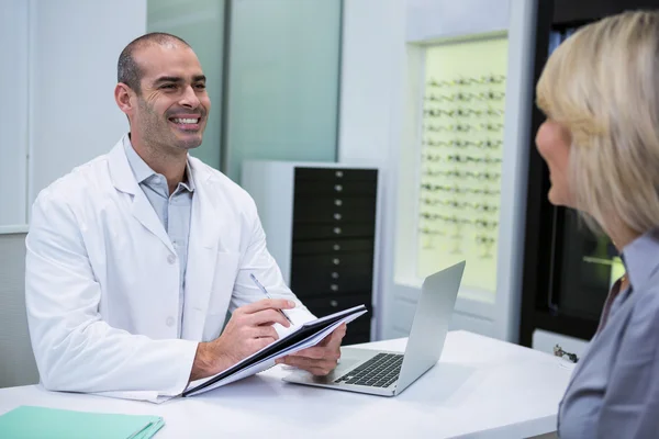 Male optometrist talking to female patient — Stock Photo, Image