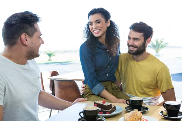 Amigos interactuando entre sí en la cafetería —  Fotos de Stock