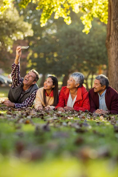 Man met familie nemen selfie op park — Stockfoto