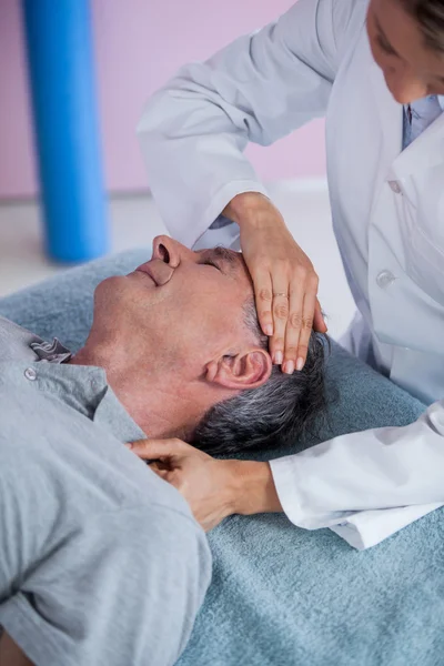 Hombre mayor recibiendo masaje en el cuello de fisioterapeuta —  Fotos de Stock