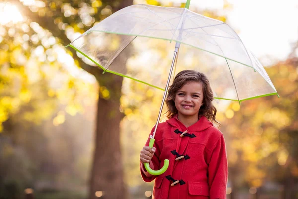 Cute girl with umbrella at park — Stock Photo, Image