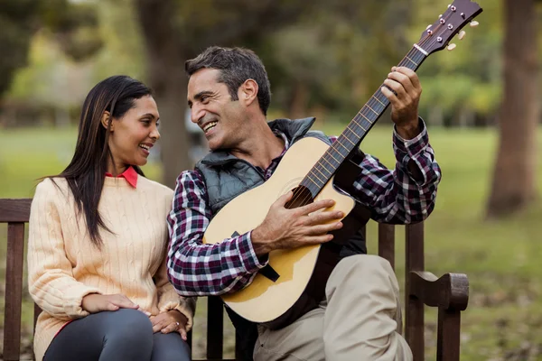 男人与女人在长椅上弹吉他 — 图库照片
