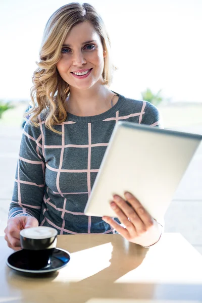 Mujer usando tableta digital mientras toma una taza de café — Foto de Stock