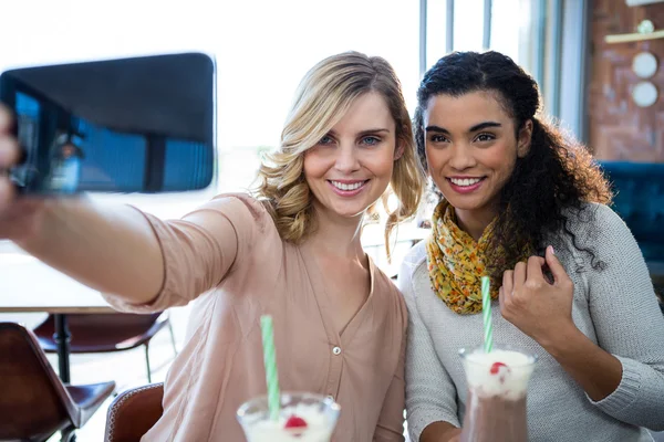 Female friends taking a selfie on mobile phone — Stock Photo, Image