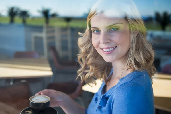 Femme souriante tenant une tasse de café — Photo