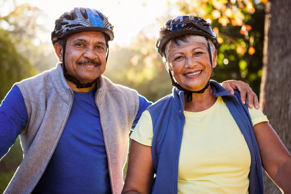 Maduro casal segurando ciclismo capacete — Fotografia de Stock