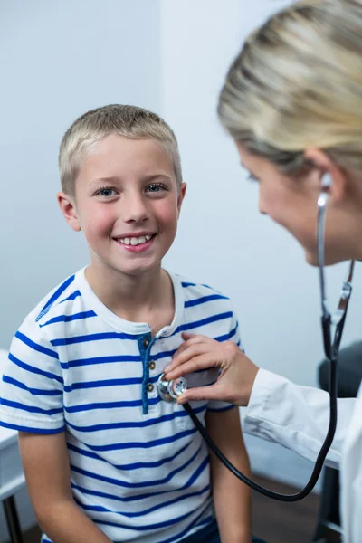 Médica examinando paciente jovem com estetoscópio — Fotografia de Stock