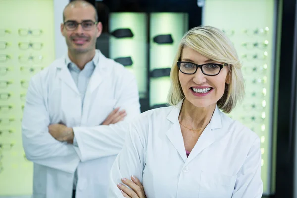 Smiling optometrists standing with arms crossed — Stock Photo, Image