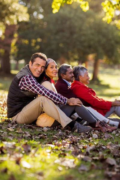 Familia sonriente relajándose en el parque —  Fotos de Stock