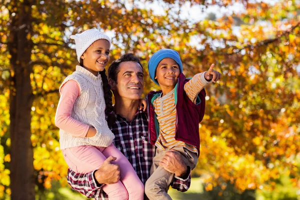 Padre che porta i bambini contro l'albero — Foto Stock