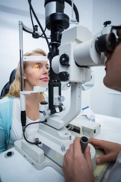 Optometrista examinando paciente feminina em lâmpada de fenda — Fotografia de Stock